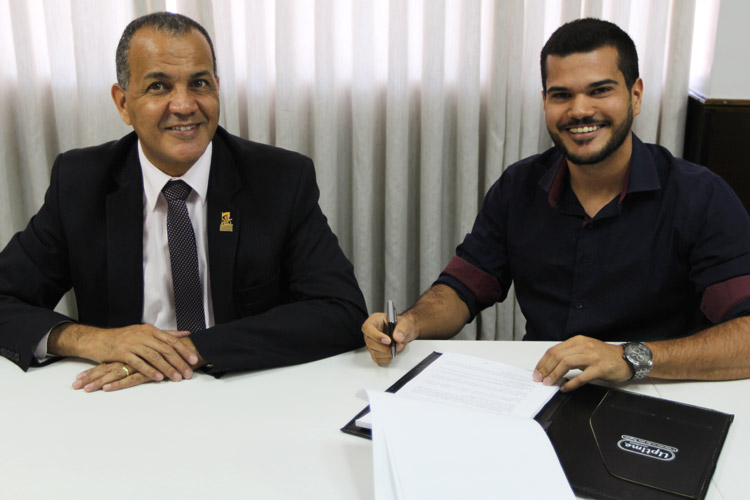 Gustavo Moutinho (à dir.) assinando o contrato na companhia de Halbert Camilo, gestor de franquias e novos negócios